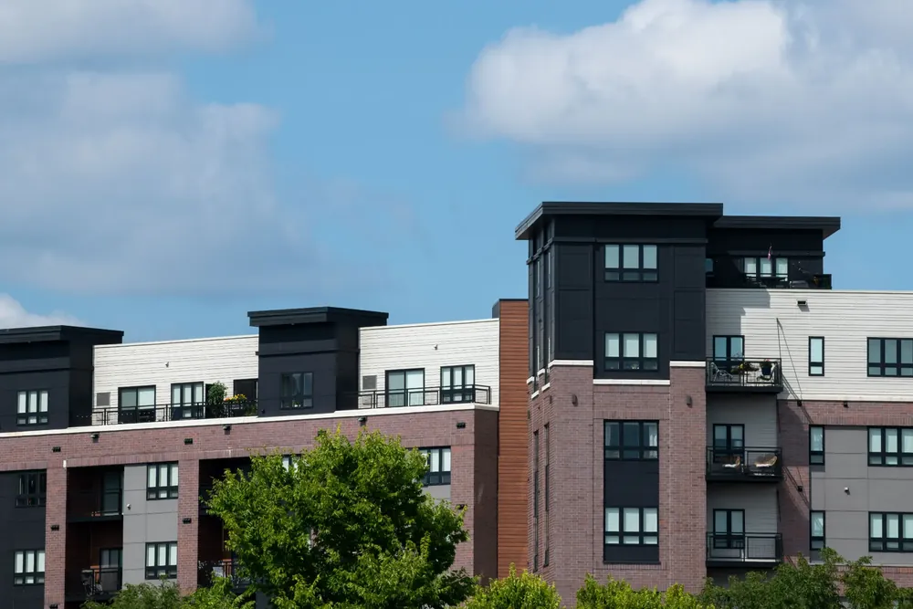 Residential buildings with brick facades, balconies and trees